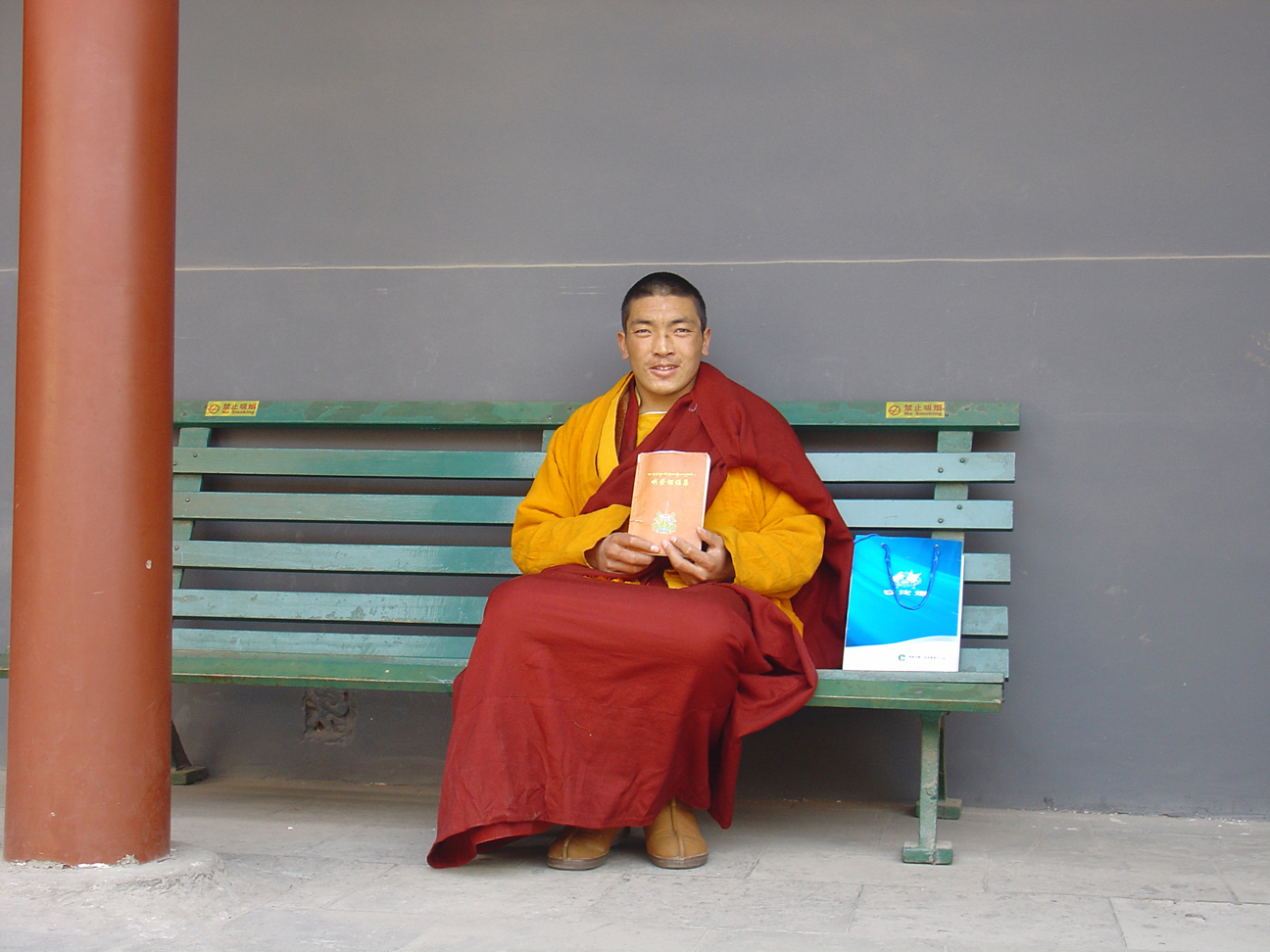 A Buddhist monk resting on a bench