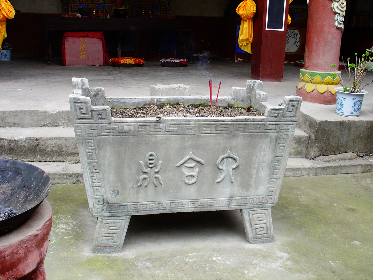 A huge stone ashtray where the praying people can insert their incenses