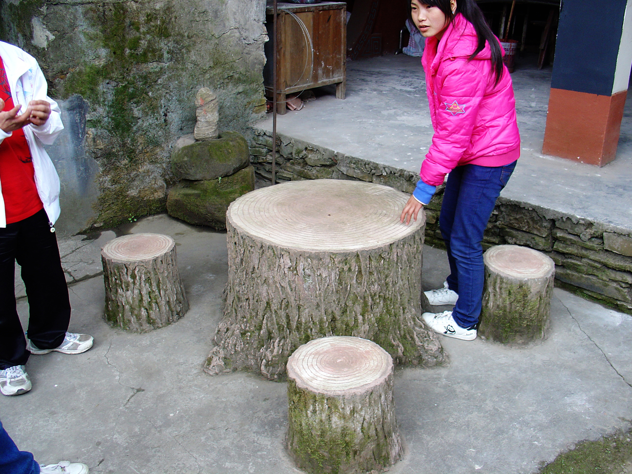 A table and four chairs made out og an old tree - the young girl is counting the annual rings