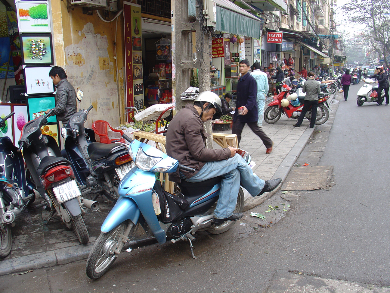 A man sitting on his motorbike waiting for customers