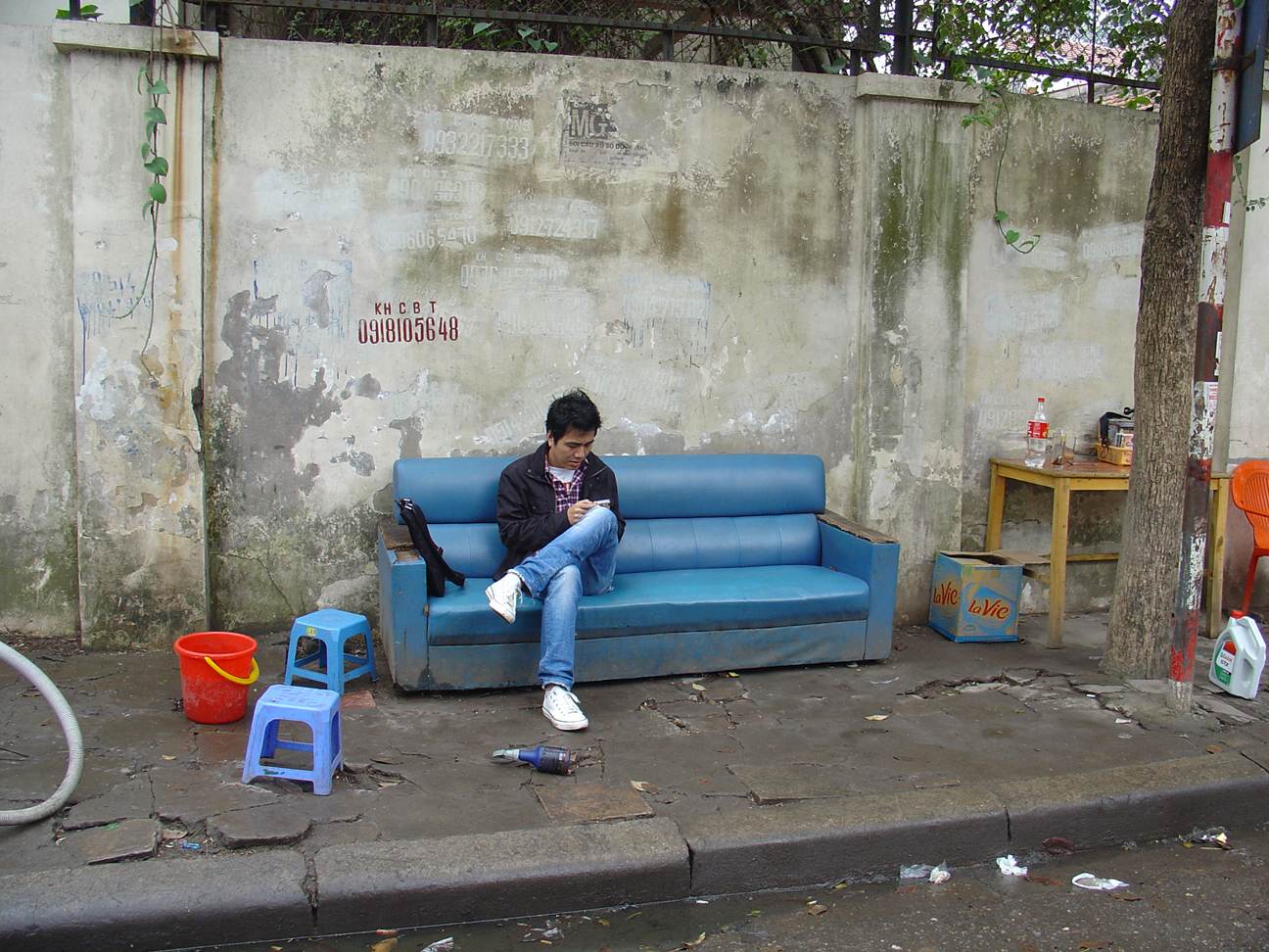 A man sitting on a couch at the street.