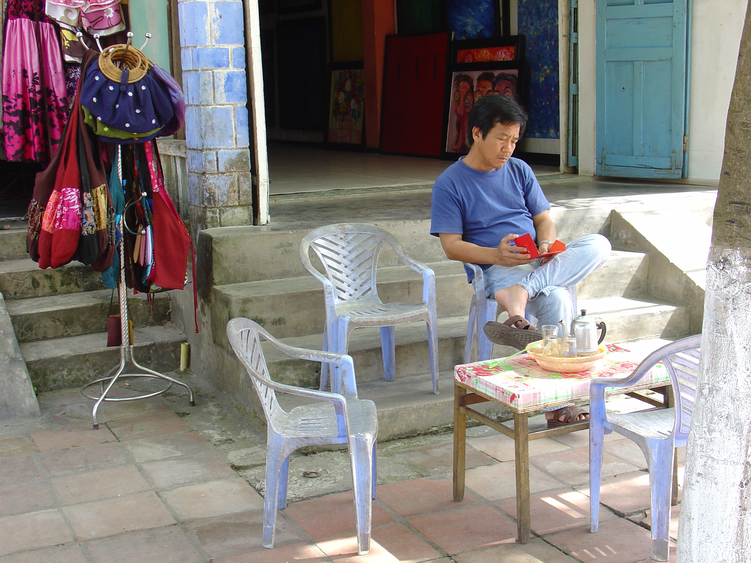A man resting in front of his shop.