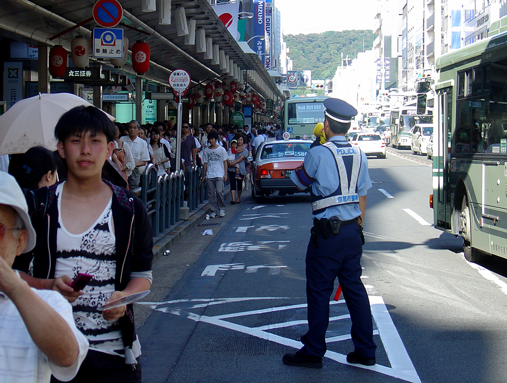 A policeman making announcements at Shijo-dori