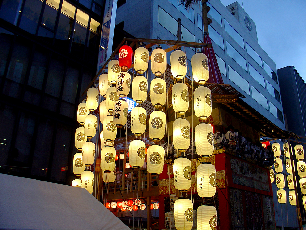A float at sunset featuring lanterns and artists.