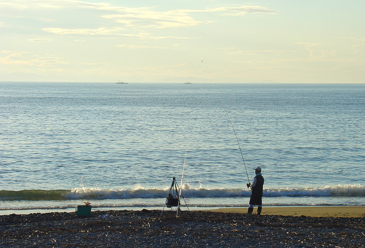 A man fishing in the early morning.