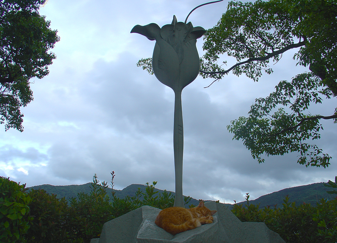 A cat sleeping in a peace sculpture.