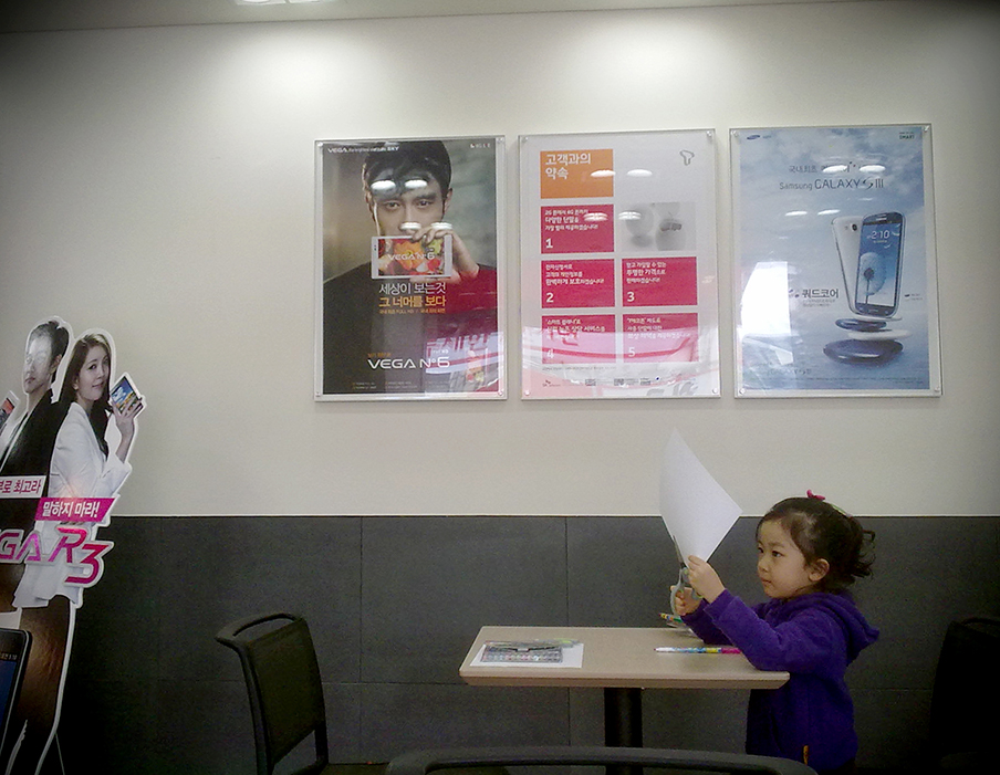 A girl playing in a mobile phone store.